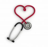 A red stethoscope arranged so that the tube looks like a heart